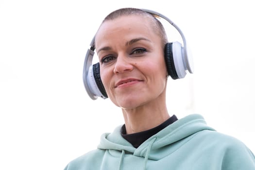 Portrait Fit woman smiling at camera with headphones on. Woman having fun during her morning workout.