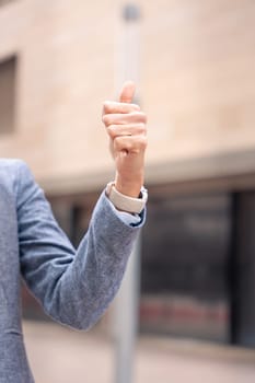 Unrecognizable Middle adult female, caucasian female, pointing with thumbs up. Happy facial expression.