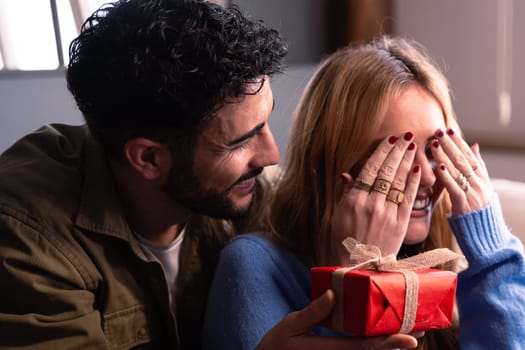 Beautiful young couple enjoying time together while celebrating Valentine's Day giving gifts.