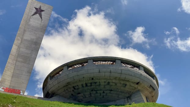 Monument Buzludzha, two torches on mountain top with spaceship background. Communist monument. Historical landmark from Bulgaria. Cloudy, sunny day - Europe