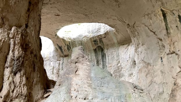 Prohodna Cave in Bulgaria, featuring the iconic God's Eyes openings, a natural rock formation resembling eyes. Majestic natural wonder. Dramatic light filters from the holes above - Karlukovo, Europe