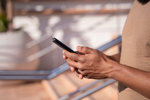 Black man hands typing on phone browsing mobile phone on social media