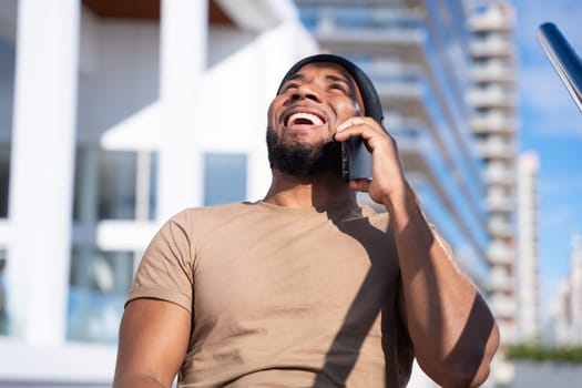 Latino Man in Black Beanie Talks on Cell Phone and Smiles