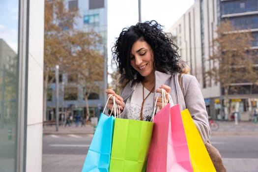 Woman shopping. Happy woman looking at shopping bags enjoying on shopping. Consumerism, shopping, lifestyle concept