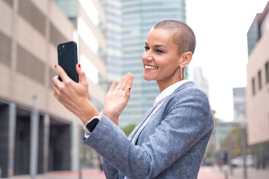 Beautiful happy caucasian adult woman in suit smiling having a work video call