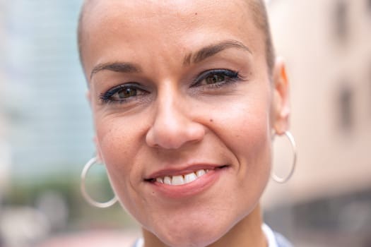 Caucasian business woman looking smiling at camera in a suit standing in an outdoor workspace. Front view of a young lawyer with positive expression staring