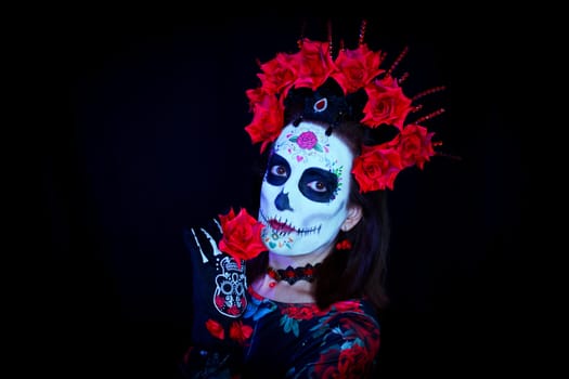 Woman dressed as a Mexican Catrina with a crown of red and black flowers