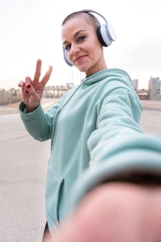 Sporty woman taking a break taking a self-portrait with her cell phone looking at camera