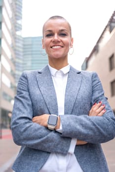 Close-up of a caucasian businesswoman looking happy at the camera in a suit standing in outdoor workspace. Front view of a young lawyer with thoughtful expression staring