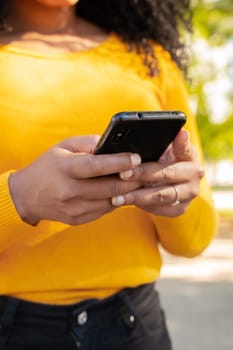 Close-up image of female hands typing text messages with an application via cell phone, using social media concept
