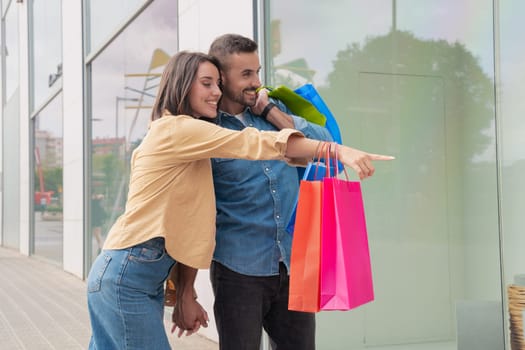 girl and boy holding shopping bags and searching retail stores.
