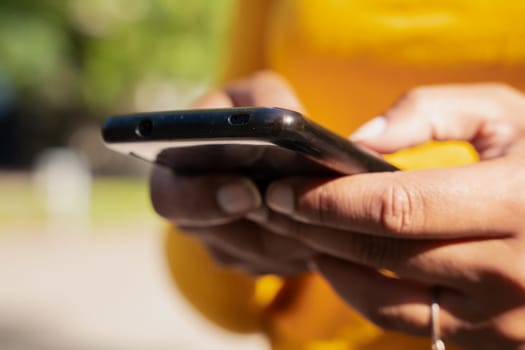 Close-up image of a female hands typing text messages via cell phone, social network concept