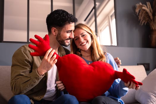 Young couple smiling with a giant heart. Valentine's Day.