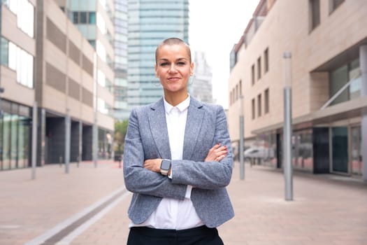 Close-up of a caucasian businesswoman looking happy at the camera in a suit standing in outdoor workspace. Front view of a young lawyer with thoughtful expression staring