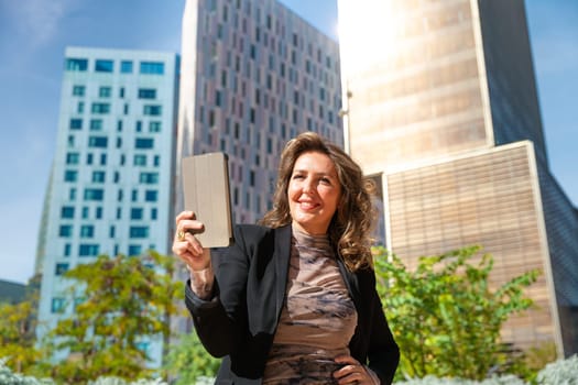 Portrait of a smiling middle-aged business woman with digital tablet in smiling hands looking at camera