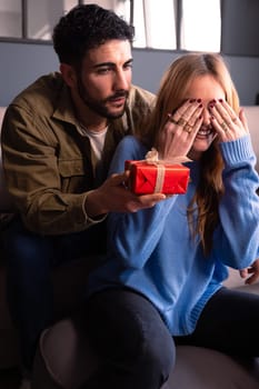 Beautiful young couple enjoying time together while celebrating Valentine's Day giving gifts.