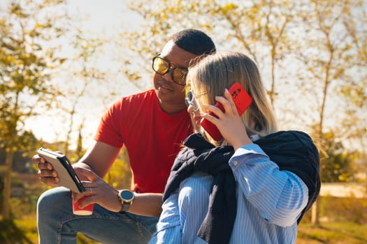 young man with sunglasses showing his friend a video on the digital tablet having fun an afternoon together in the park.