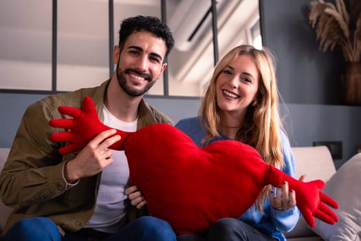 Young couple smiling with a giant heart. Valentine's Day.