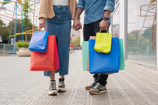Midsection of couple with shopping bags in the city