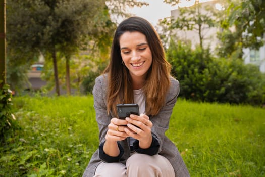 Young woman with cell phone in her hands, writes messages and reads news online, using an app with a surprised gesture.