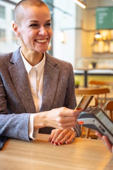 Vertical portrait Happy woman holding a credit card and making a payment transaction.