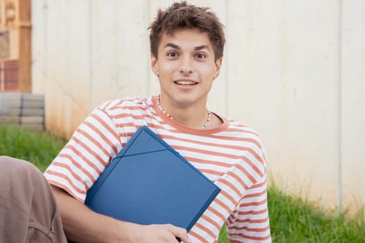caucasian Student sitting on campus with a folder leaving class. University life concept.