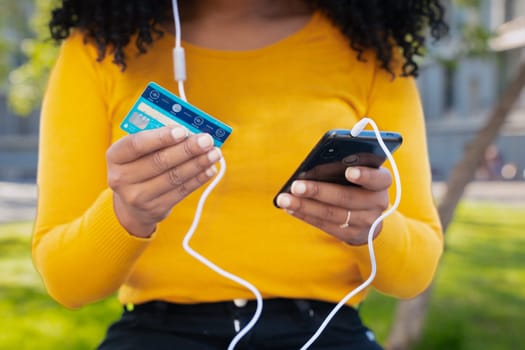 Anonymous happy woman with credit card and smartphone in hands. Concept: online shopping