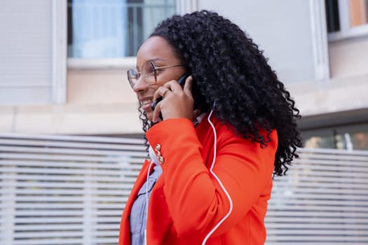Beautiful happy black business woman talking on mobile phone outdoors. Girl talking on mobile phone