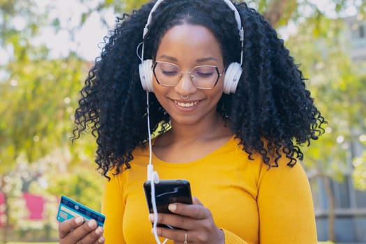 happy woman with credit card and smartphone in hands. Concept: online shopping