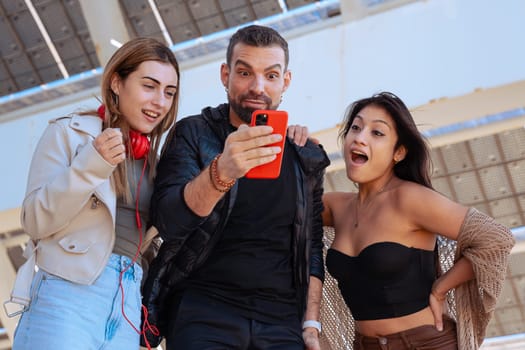 Group Of Three Young Happy Gay And Lesbian Friends Looking at social media with a cell phone app. Concept: pride, lgtbi, friendship