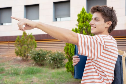 Caucasian teenage student pointing finger to the side of the logo. Man showing signs