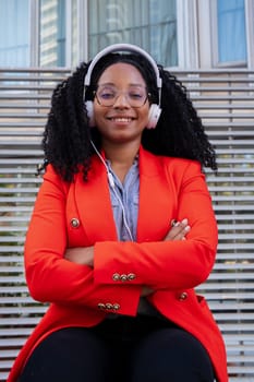 Young smiling businesswoman with headphones looking at camera. Front view of a black woman Head shot of a proud businesswoman