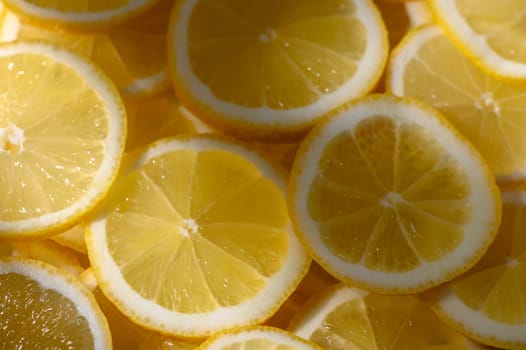 Bright yellow lemon slices are laid out in an artistic arrangement, exuding freshness and inviting summer vibes.