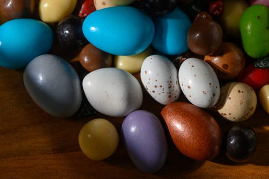 Various decorative eggs with vibrant colors are scattered across a warm wooden surface, creating a cheerful ambiance.