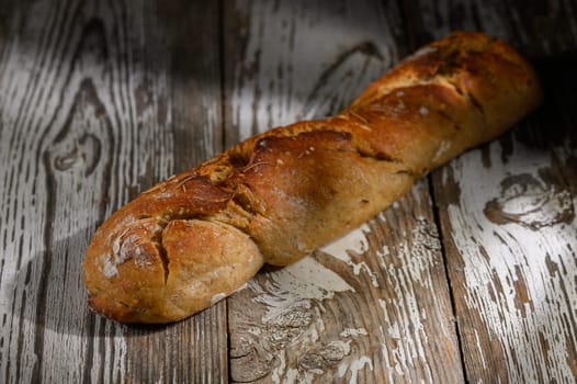 Golden-brown crust of artisan bread sits elegantly on rustic wood, highlighting its texture and warmth.