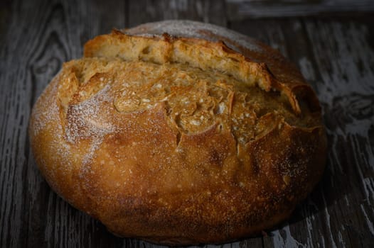 Freshly baked artisan bread with a golden crust, resting on a weathered wooden table, exuding warmth and comfort.