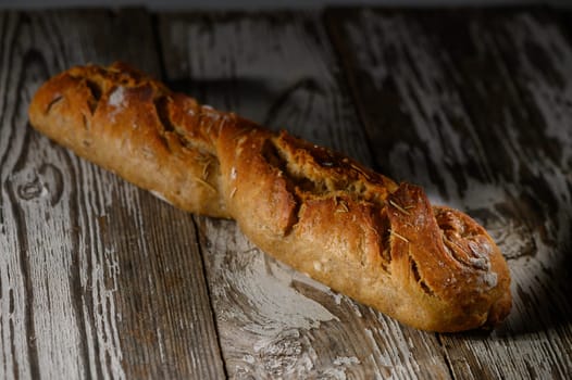 A beautiful rustic bread loaf sits gracefully on a weathered wooden surface, glowing in gentle light, inviting all.
