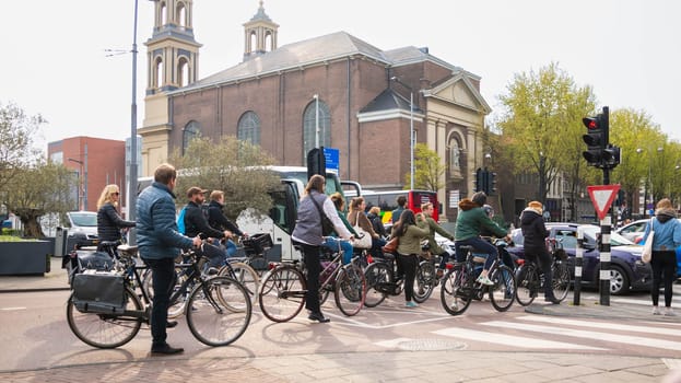 AMSTERDAM, THE NETHERLANDS - APRIL 16, 2019: The Cyclists on bicycles wait for a green traffic light