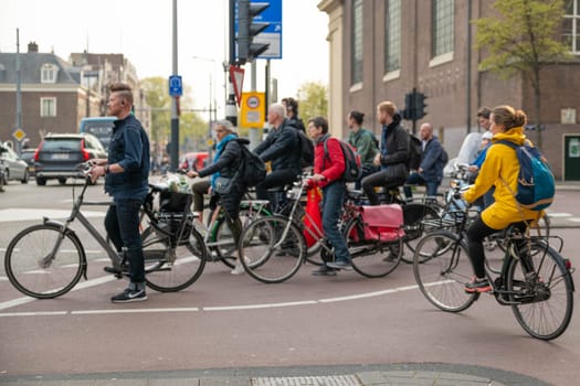 AMSTERDAM, THE NETHERLANDS - APRIL 16, 2019: The Cyclists on bicycles wait for a green traffic light