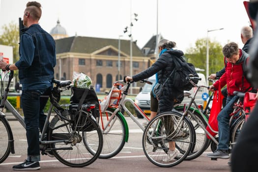 AMSTERDAM, THE NETHERLANDS - APRIL 16, 2019: The Cyclists on bicycles wait for a green traffic light