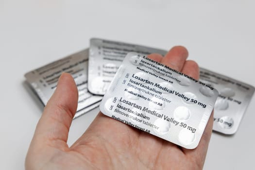 Female hands holding Losartan high blood pressure pills in blister. Prescription medication. Copenhagen, Denmark - February 11, 2025