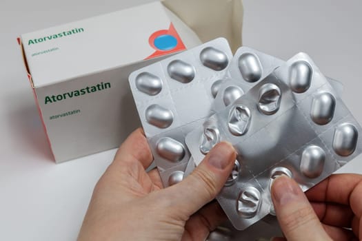 Female hands holding Atorvastatin against high cholesterol in the bkood pills. Copenhagen, Denmark - February 11, 2025