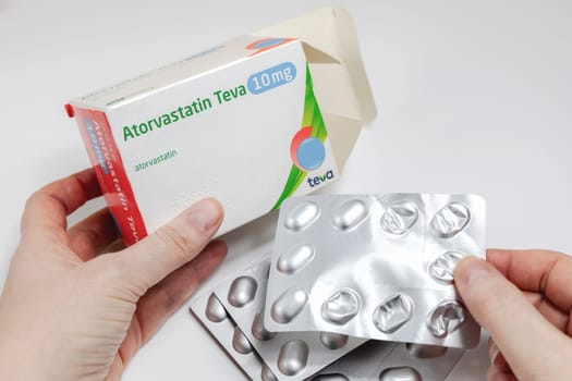 Female hands holding Atorvastatin against high cholesterol in the bkood pills. Copenhagen, Denmark - February 11, 2025