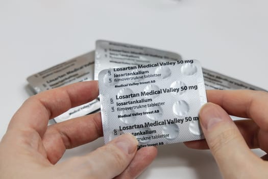 Female hands holding Losartan high blood pressure pills in blister. Prescription medication. Copenhagen, Denmark - February 11, 2025