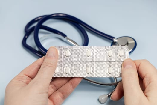 Female hands holding pills in blister. Prescription medication. High quality photo