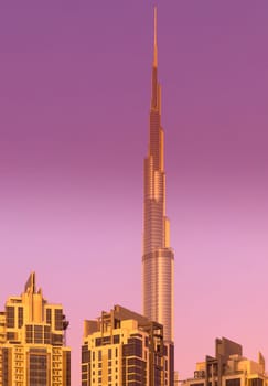 UAE, Dubai, 25 November 2024: The famous Burj Khalifa skyscraper at dusk, Dubai's sights during the incredible sunset sky, skyscrapers illuminated at night, pink sky, palm trees. High quality photo