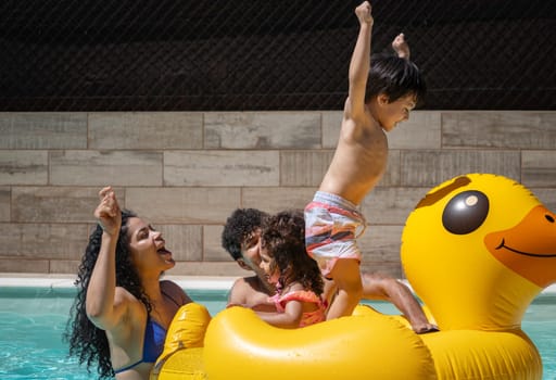 Excited family playing on inflatable duck float in swimming pool, enjoying summer vacation.