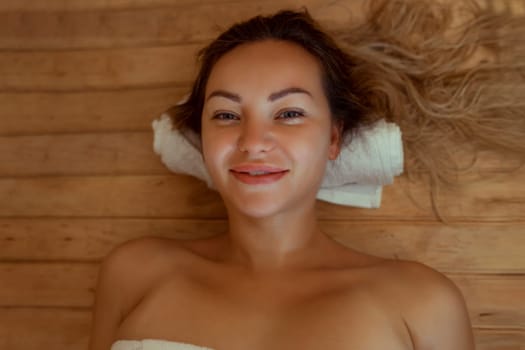 Beautiful young woman relaxing in Finnish sauna.