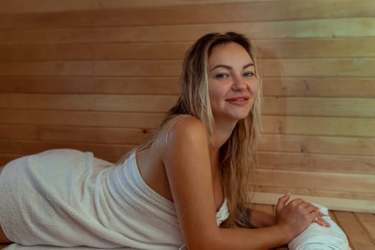Beautiful young woman relaxing in Finnish sauna.