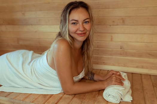 Beautiful young woman relaxing in Finnish sauna.